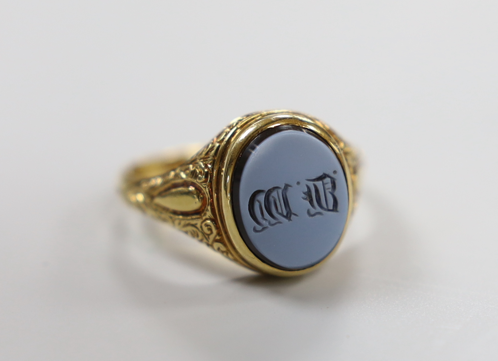 A late Victorian 18ct gold and sardonyx set mourning ring, with engraved initials, the hinged ring head opening to reveal plaited hair?, size Q/R, gross weight 10 grams.